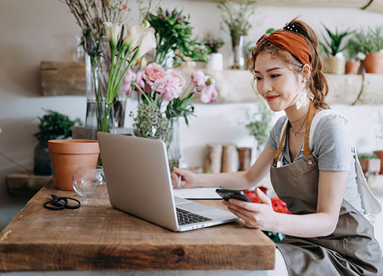 Woman using laptop in a floral shop