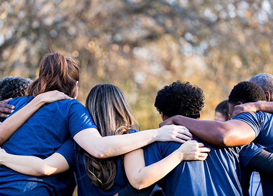 Group of people with arms across shoulders