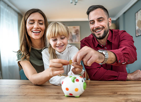 Couple with child putting coins in bank