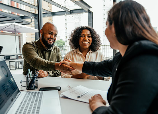 Man and Woman shaking hands over desk