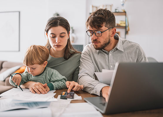 Parents and Small Child with laptop and paperwork